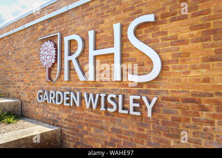 Logo e nome segno su un muro di mattoni al nuovo ingresso alla RHS Garden, Wisley, Surrey, una popolare attrazione turistica nel sud-est Inghilterra Foto Stock