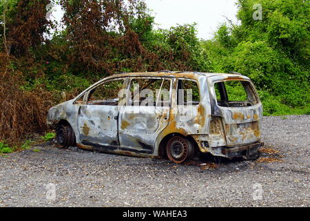 Store Heddinge, Danimarca - Agosto 12, 2019: bruciata Volkswagen Touran dal lato della strada. Nessuno nel veicolo. Foto Stock