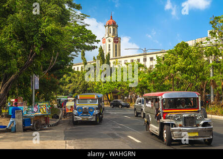 Street View di Manila con jeepney e torre dell'orologio Foto Stock