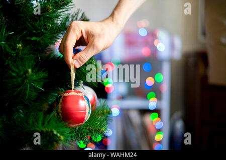 Close-up di decorazione a mano l'albero di natale con una bella palla rossa toy f Foto Stock