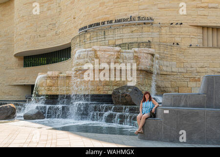 Washington DC, Stati Uniti d'America. 29/07/2019. Donna seduta vicino a cascata presso il Museo Nazionale degli indiani americani. Foto Stock