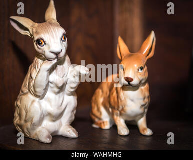 Due porcellane vintage bunny figurine con sfondo di legno. Concetto di pasqua Foto Stock