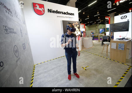 Colonia, Germania. 20 agosto 2019. Un visitatore del gamescom gioca un gioco per computer con occhiali VR presso lo stand di pellicola Nordmedia- und Mediengesellschaft Niedersachsen/Bremen GmbH. Bassa Sassonia vuole presentare se stesso maggiore prima di quest'anno al gamescom di Colonia. Credito: Henning Kaiser/dpa/Alamy Live News Foto Stock