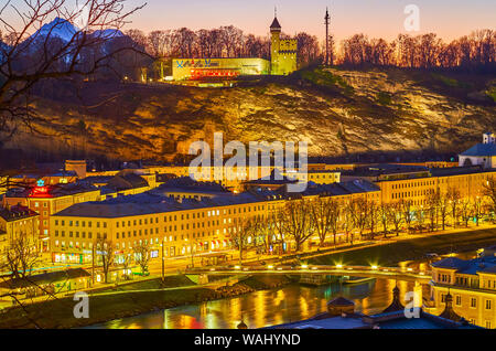 Salisburgo, Austria - 27 febbraio 2019: la linea di case lungo gli argini del fiume Salzach e il Museo di Arte Moderna sulla collina, il 27 febbraio in Foto Stock