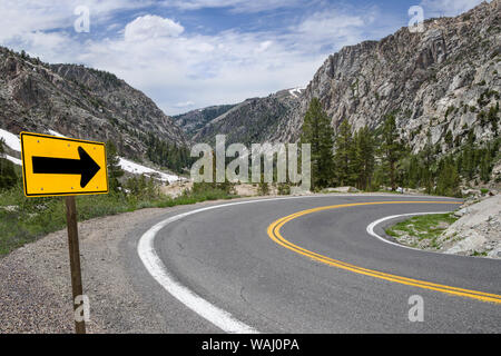 Sharp Avviso Svolta freccia: un segno indica la strada lungo una strada tortuosa attraverso montagne della Sierra Nevada. Foto Stock