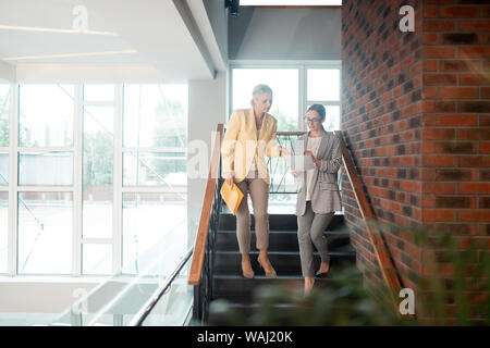 Due concentrati di colleghe in piedi nella hall Foto Stock