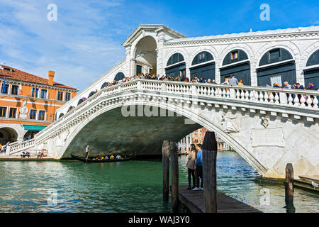 Il Ponte di Rialto (Ponte di Rialto) sul Canal Grande, con una gondola passando al di sotto. Dal Pescaria San Bortolomio, Venezia, Italia Foto Stock