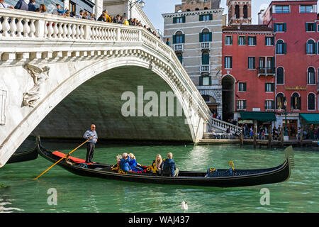 Il Ponte di Rialto (Ponte di Rialto) sul Canal Grande, con una gondola passando al di sotto. Dalla Riva del Vin, Venezia, Italia Foto Stock