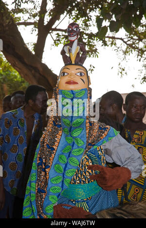 Africa occidentale Benin. Maschera Gelede ballerina sorge nella parte anteriore del gruppo di uomini. Foto Stock