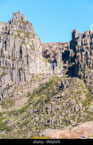 Australia e Tasmania, Cradle Mountain-Lake St Clair National Park. Mt Ossa vetta più alta del parco. Gli escursionisti sul sentiero sopraffatte da massi Foto Stock