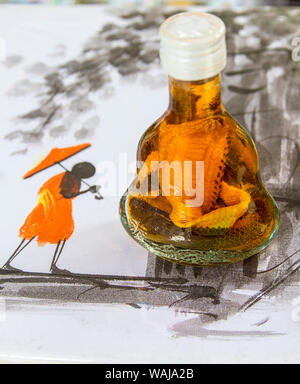 Phnom Penh Cambogia. Il vino di riso in plastica con il modello di serpente cobra venduto come un souvenir seduto su di un dipinto di un locale rurale scena cambogiano. (Solo uso editoriale) Foto Stock