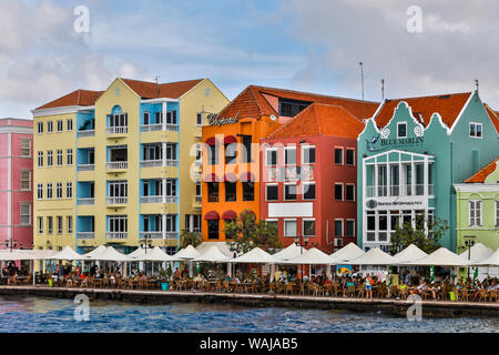 Piccole Antille, Curacao Willemstad. Persone rilassante lungo il lungomare in corrispondenza del bordo del quartiere per lo shopping Foto Stock