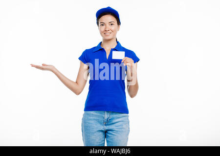 La ragazza di post office pone uniforme in corrispondenza della fotocamera con la carta come se vi è qualcosa di diverso nella sua mano. Foto Stock