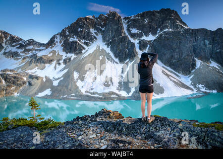 Canada, British Columbia, Wedgemount Lago. Escursionista pause a fotografare il lago alpino. (MR) Foto Stock