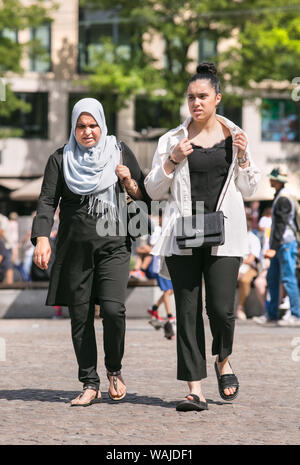 I popoli islamici su una soleggiata Piazza Dam. Con circa 178 diversi background culturali, Amsterdam è un vivace e colorata miscela di persone. Foto Stock