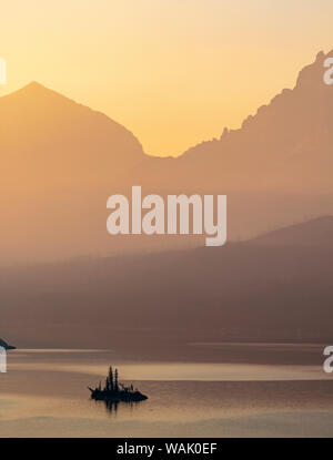 Wild Goose Island retroilluminati da smoky skies nel Parco Nazionale di Glacier, Montana, USA Foto Stock