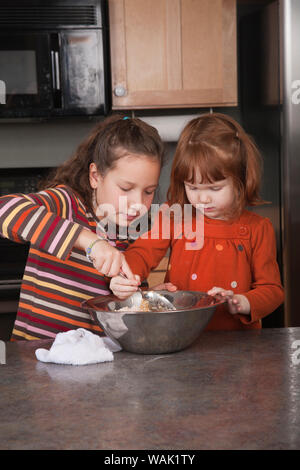 Sorelle agitazione pasta biscotto. (MR, PR) Foto Stock