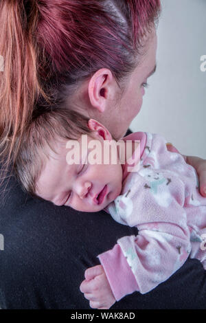 Madre teneramente holding suo sonno dodici giorni di età bambina. (MR) Foto Stock