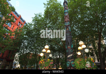 Cesti floreali pendenti. Tlingit Totem Pole, a Pagoda, Pioneer Square, l'area storica, Seattle, nello Stato di Washington, USA Foto Stock