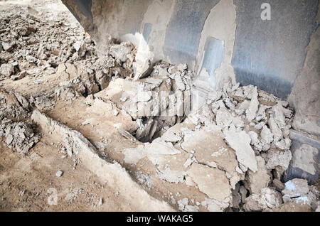 Chiudere l immagine di un escavatore i denti della benna in scavo la sporcizia, il fuoco selettivo. Foto Stock
