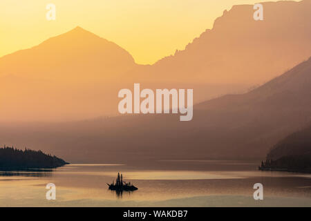 Wild Goose Island retroilluminati da smoky skies nel Parco Nazionale di Glacier, Montana, USA Foto Stock