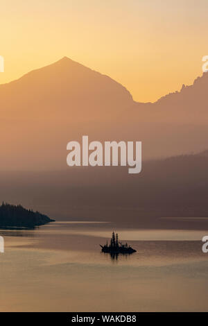 Wild Goose Island retroilluminati da smoky skies nel Parco Nazionale di Glacier, Montana, USA Foto Stock