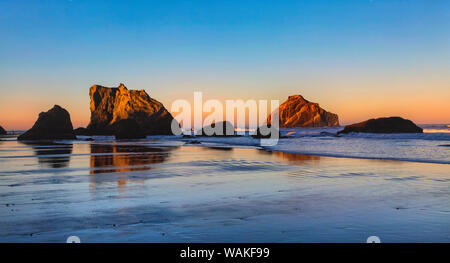 Stati Uniti d'America, Oregon, Bandon. Tramonto sulla spiaggia mare pile. Credito come: Jean Carter Jaynes / Galleria / DanitaDelimont.com Foto Stock