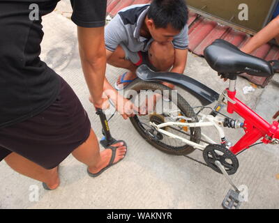 La gente di pompaggio pneumatici di bicicletta Foto Stock