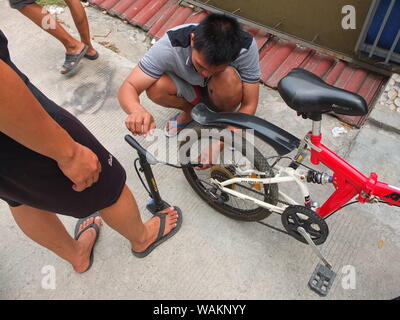 La gente di pompaggio pneumatici di bicicletta Foto Stock