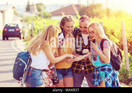 Hipster amici sul viaggio avventura nel lato paese guardando la mappa per la nuova destinazione di viaggio Foto Stock