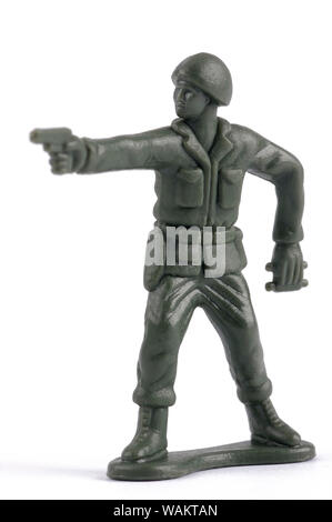 Un soldato giocattolo puntando la sua pistola isolati su sfondo bianco Foto Stock