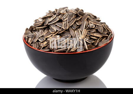 Una ciotola nera di semi di girasole, uno spuntino gustoso e sano, ricco di nutrienti ed energia per una rapida carica. Foto Stock