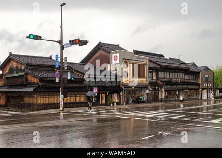 Una persona con un ombrello a piedi attraverso un passaggio pedonale in Higashiyama, Kanazawa, Giappone, in un giorno di pioggia Foto Stock