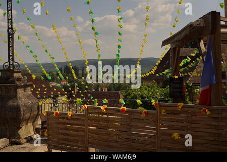 Una vista di un rurale villaggio francese di scena e colline circostanti e la campagna da un patio giardino Foto Stock