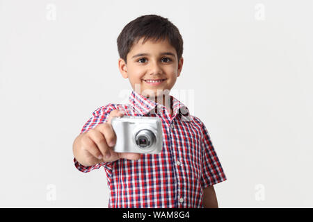 Ragazzo di scattare una foto con la fotocamera digitale Foto Stock