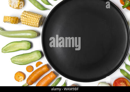 Vari ortaggi freschi e le erbe su sfondo bianco. Layout creativo fatto di fagioli bianchi, pomodori, peperone, carota, aglio, mais, le zucchine, la cipolla Foto Stock