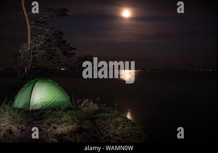 Il campeggio per una notte stellata. La tenda si accende sotto il cielo notturno pieno di stelle. Foto Stock