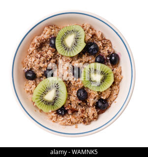 Tutto il frumento Cereali con le fette di kiwi e mirtilli, isolato su bianco. Foto Stock