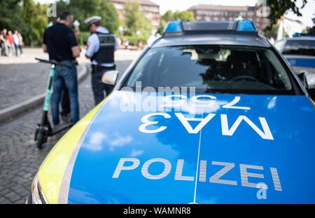 21 agosto 2019, Baden-Wuerttemberg, Stoccarda: Durante un controllo di polizia, un'e-scooter driver è avvertito dalla polizia perché egli ha guidato su un percorso pedonale. Foto: Fabian Sommer/dpa Foto Stock