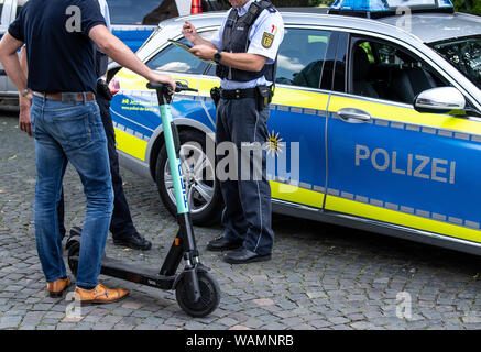 21 agosto 2019, Baden-Wuerttemberg, Stoccarda: Durante un controllo di polizia, un'e-scooter driver è avvertito dalla polizia perché egli ha guidato su un percorso pedonale. Foto: Fabian Sommer/dpa Foto Stock