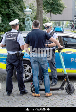 21 agosto 2019, Baden-Wuerttemberg, Stoccarda: Durante un controllo di polizia, un'e-scooter driver è avvertito dalla polizia perché egli ha guidato su un percorso pedonale. Foto: Fabian Sommer/dpa Foto Stock