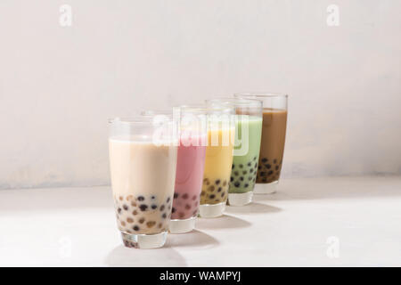 Varie aromatizzati buble tè o boba tè con cannucce su sfondo bianco Foto Stock