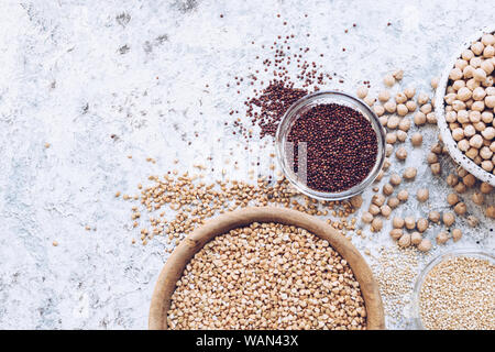 Assortimento di vari cereali e semi di bocce su sfondo grigio: la quinoa, verde di grano saraceno e i ceci. Senza glutine cibo sano. La dieta, dieta Foto Stock