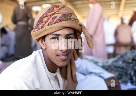 Giovane ragazzo indossa velo colorato al mercato Sinaw, Oman Foto Stock