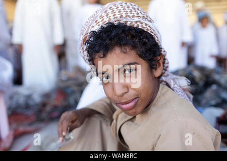 Giovane ragazzo indossa velo colorato al mercato Sinaw, Oman Foto Stock