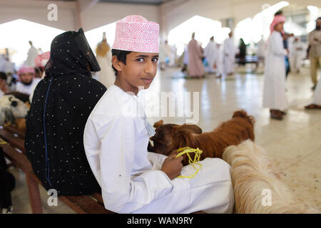 Giovane ragazzo indossare copricapo colorati al mercato Sinaw, Oman Foto Stock