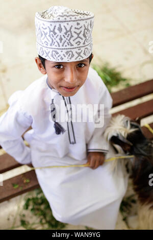 Giovane ragazzo indossa colorata cappuccio ricamato al mercato Sinaw, Oman Foto Stock