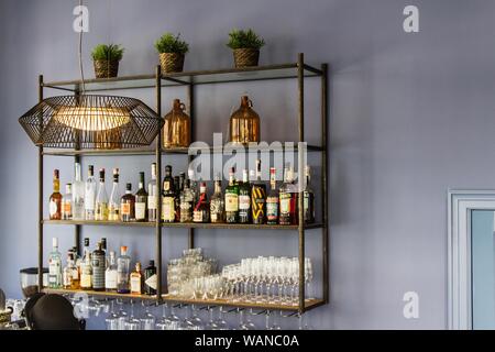Foto interna di un bar con pareti blu e diversi bere i biberon sullo scaffale Foto Stock