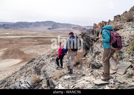 Mongolia Ulgii 2019-05-04 gruppo turistico escursioni e arrampicate unitamente alla guida, scendendo dalla cima della montagna. Vista posteriore. Concetto di libertà, zainetto Foto Stock