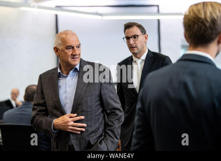 21 agosto 2019, Baden-Wuerttemberg, Stoccarda: Willi Balz (l), fondatore della società di energia Windreich AG, è in piedi in aula all'inizio della controversia in materia di insolvenza della fattoria eolica project developer Windreich. Gli imputati sono accusati di ritardare l' insolvenza e complici, come pure le frodi ammontano a diversi milioni di euro. Foto: Fabian Sommer/dpa Foto Stock